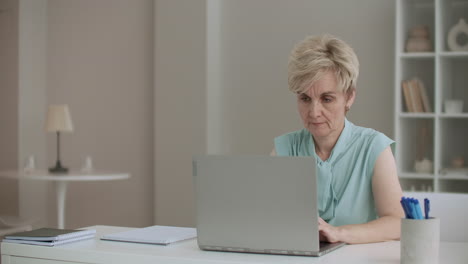 Rentnerin-Tippt-Auf-Laptop.-Schriftstellerin-Arbeitet-Und-Schreibt-Zu-Hause-Und-Blickt-Konzentriert-Auf-Das-Display