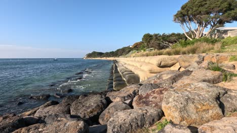 rocky shore with sandbags and clear water