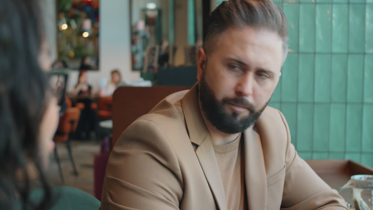 Businessman Talking with Female Colleague in Cafe