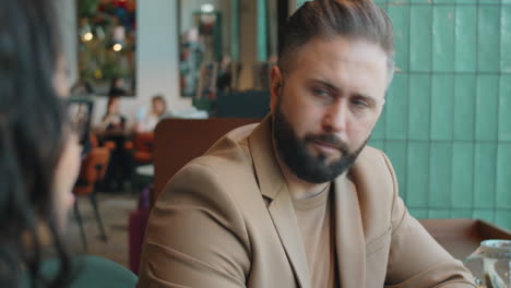 Businessman-Talking-with-Female-Colleague-in-Cafe