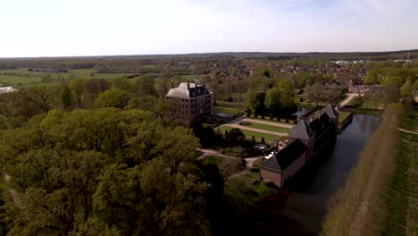 descending aerial showing surrounding lane and moat of dutch painterly picturesque castle amerongen on a bright sunny day with meadows in the foreground