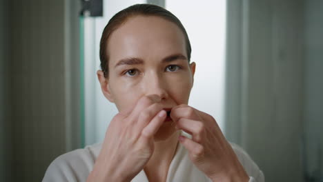 pretty lady flossing teeth looking camera closeup. girl cleaning mouth