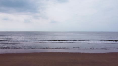 Drone-shot-of-waves-crashing-on-the-beach-of-North-sea