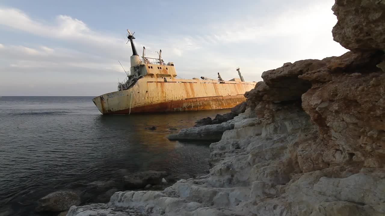 naufragio oxidado en la costa rocosa