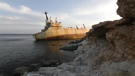 naufragio oxidado en la costa rocosa