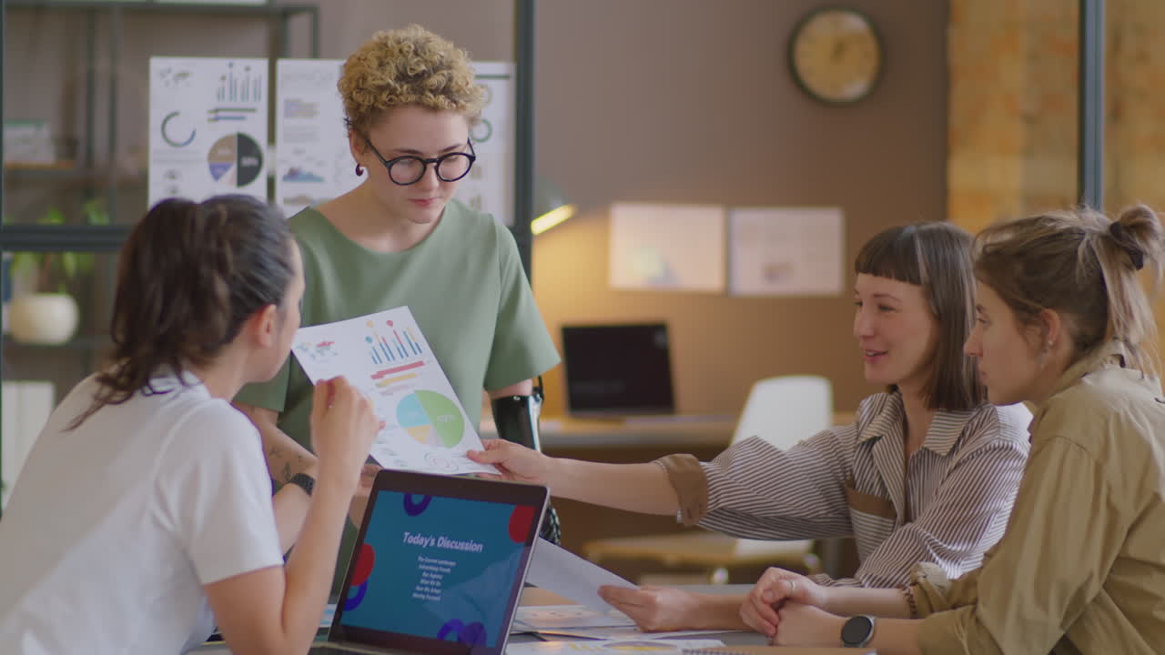 Woman with Prosthetic Arm Discussing Project with Business Team