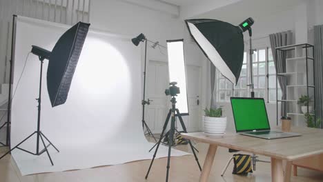 photo studio with professional equipment and green screen laptop computer display