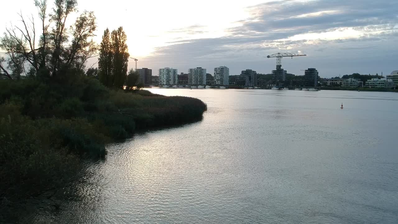 상승하는 드론이 황금 시간에 아파트 건물의 도시 스카이라인을 드러냅니다.