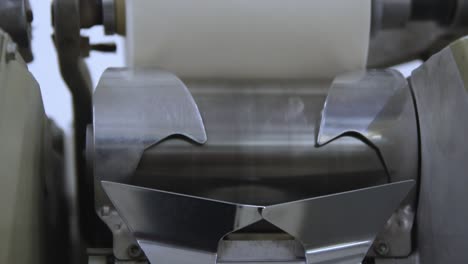 closeup shot of an automated machine manufacturing thread textiles