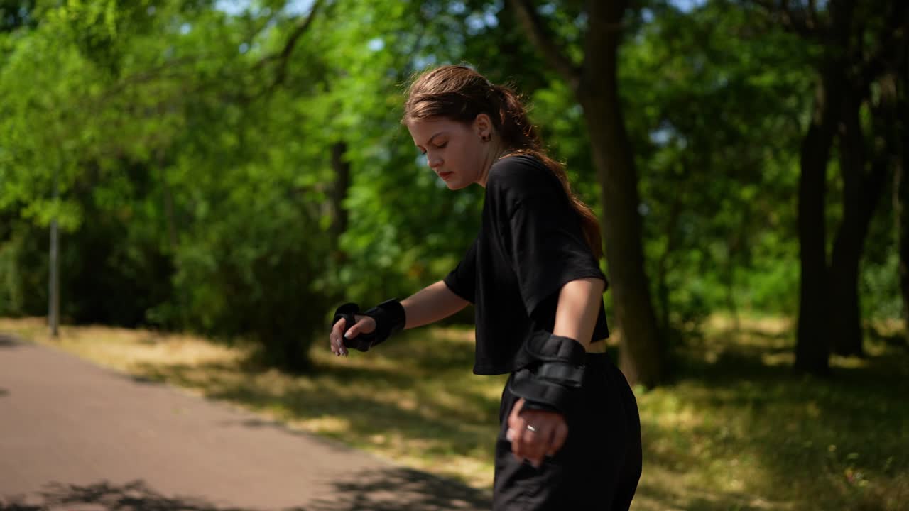십대 소녀 가 공원 에서 롤러 스케이트 를 타고 있다