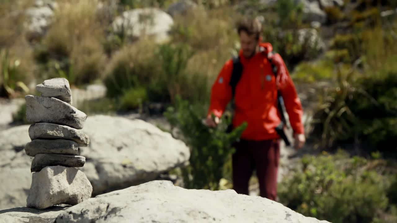 excursionista masculino caminando con mochila en el campo 4k