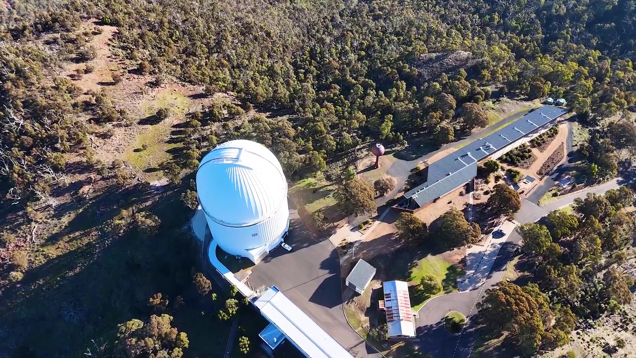 Imagem aérea de drone da cúpula branca do telescópio e da vegetação nativa circundante na Austrália