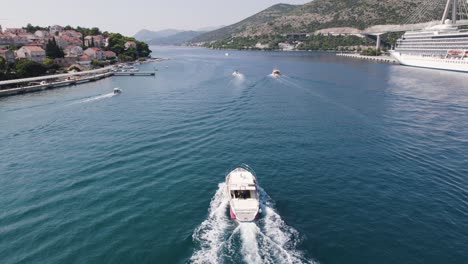 aerial tracking shot: boat sailing dubrovnik port, adriatic sea backdrop