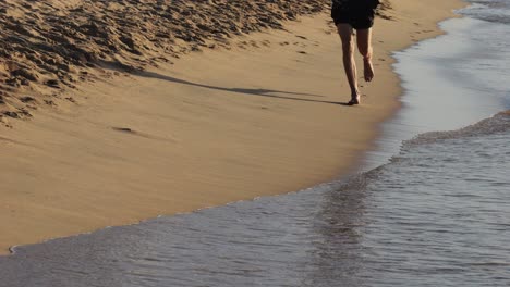 man running barefoot on the beach
