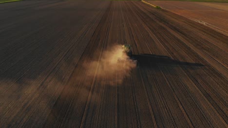 aerial shot of tractor making soil ready for cultivating crops with agricultural machinery