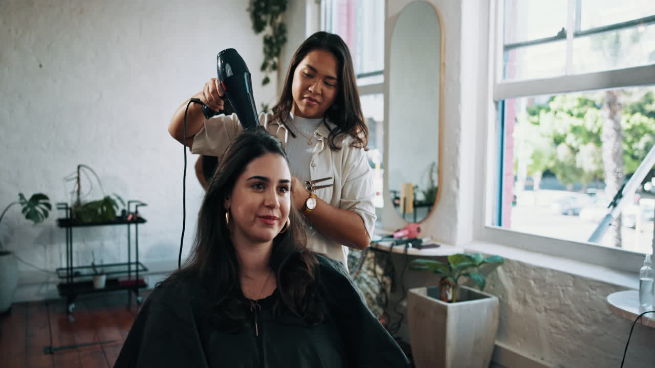 Hairdresser Blow Drying Client's Long Hair in a Modern Salon