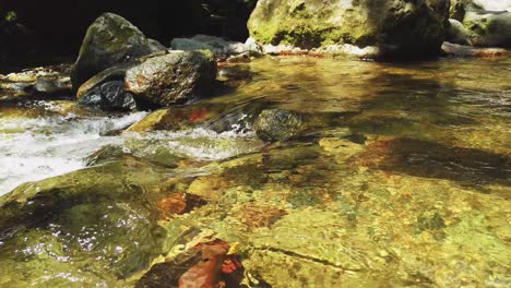 Looking-Over-Shallow-Clear-Peaceful-Waters-of-the-Saltos-Jima-Waterfall-Flowing-Past-Rocks-during-the-day,-Pan-Right-Tripod-shot