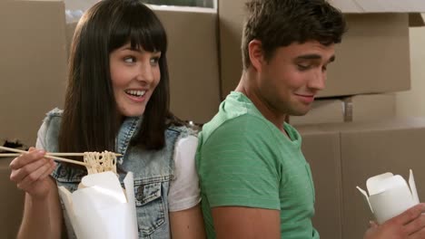 una pareja joven comiendo comida china.