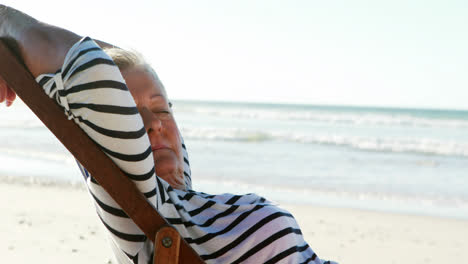 senior woman relaxing on sunlounger at beach