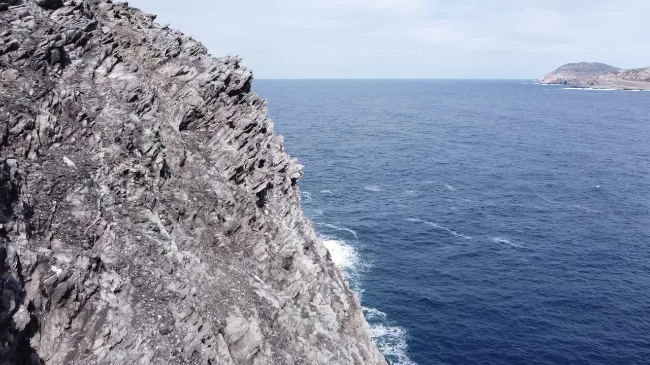 el dron vuela increíblemente cerca de las rocas afiladas con vistas al mar.