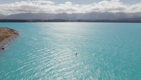 wing-foil-surfer auf dem malerischen pukaki-see mit blauem gletscherwasser