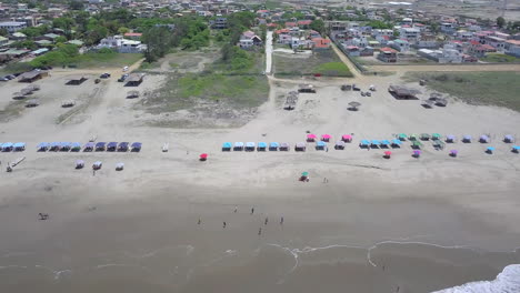 revealing drone shot from near the coast over the ocean towards the town of playas general villamil in ecuador