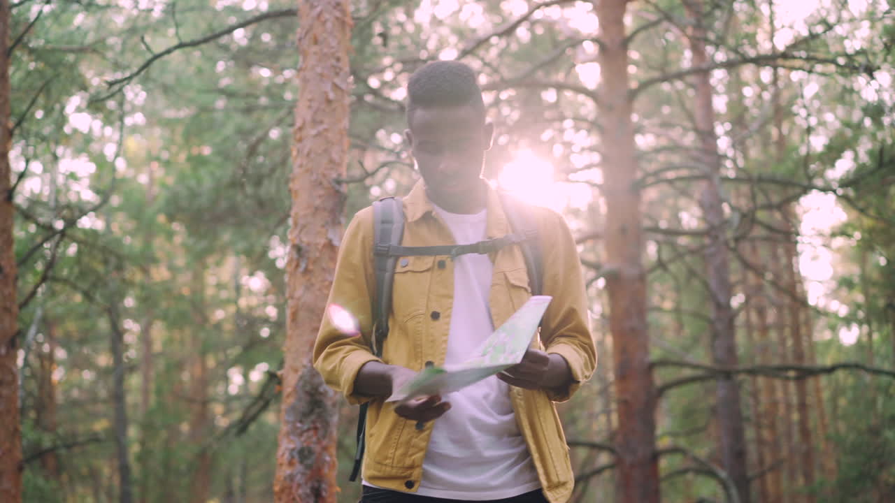 Man looking at a map in a forest