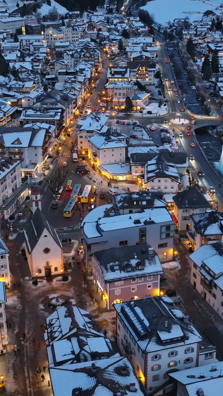 Aerial drone view of the Ortisei town covered in snow at night, within the Dolomites, in northern Italy. Vertical