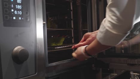 chef puts venison meat ribs inside meat baking oven