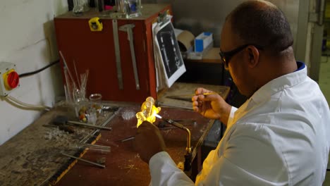 vista lateral de un trabajador masculino maduro creando vidrio en una fábrica de vidrio 4k