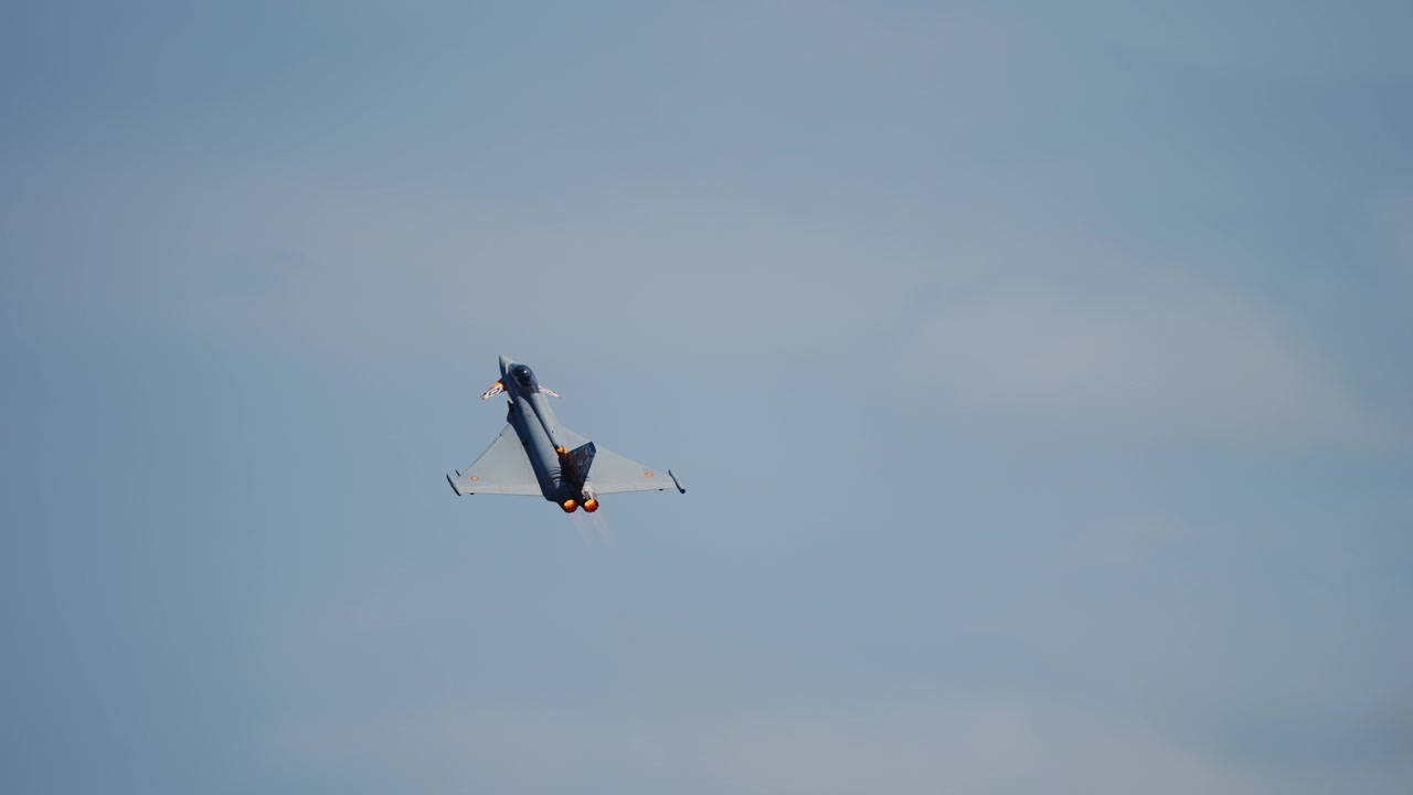 Pesawat tempur sayap delta melakukan manuver dengan afterburner