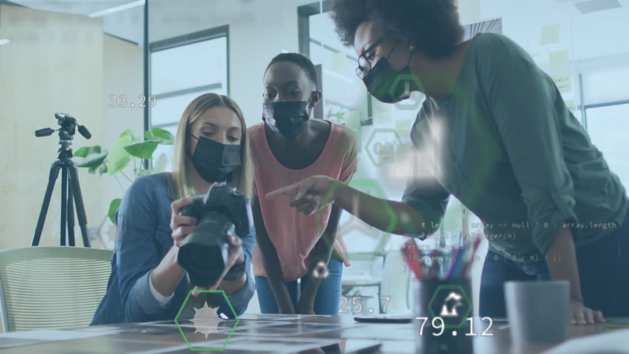 Animation of data over diverse business people wearing face masks in office