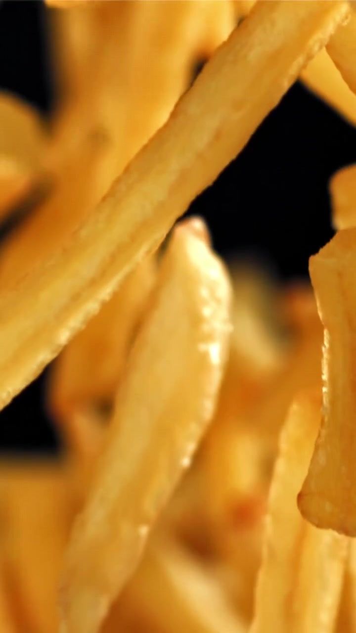 Patatas fritas doradas y crujientes cayendo a cámara lenta