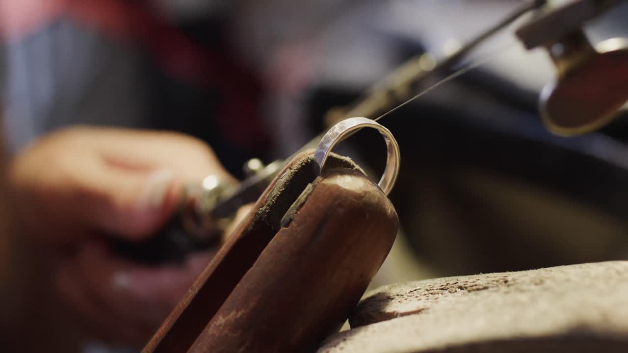 두 인종의 여성 노동자가 슬로우 모션으로 스튜디오에서 사로 보석을 형성하고 있습니다.