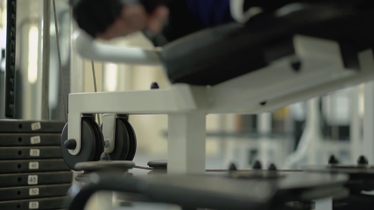 남자 는 다리 근육 을 강화 하기 위한 운동 을 한다. 장애인 을 위한 스포츠 홀 에서 수업 이 열린다.