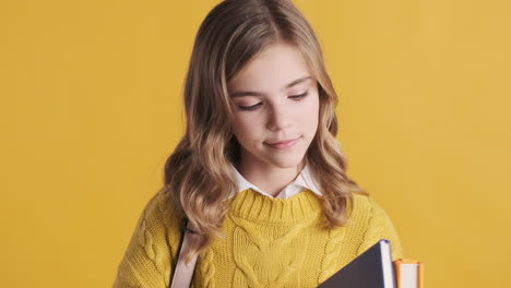 happy teenage caucasian girl student holding notebooks.