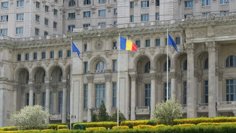 flags waving in front of palace of the parliament in bucharest, romania