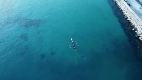 Un-Equipo-Deportivo-En-Un-Bote-De-Remos-Navega-Hacia-El-Mar-En-La-Costa-De-España