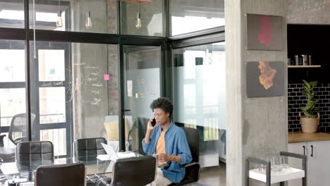 african american casual businessman on smartphone drinking coffee at home, copy space, slow motion