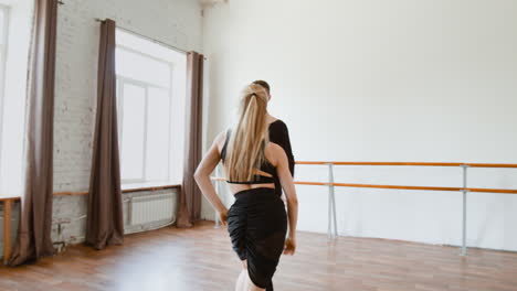 professional dance couple practicing ballroom steps in a bright studio