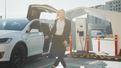 mujer cargando un coche eléctrico