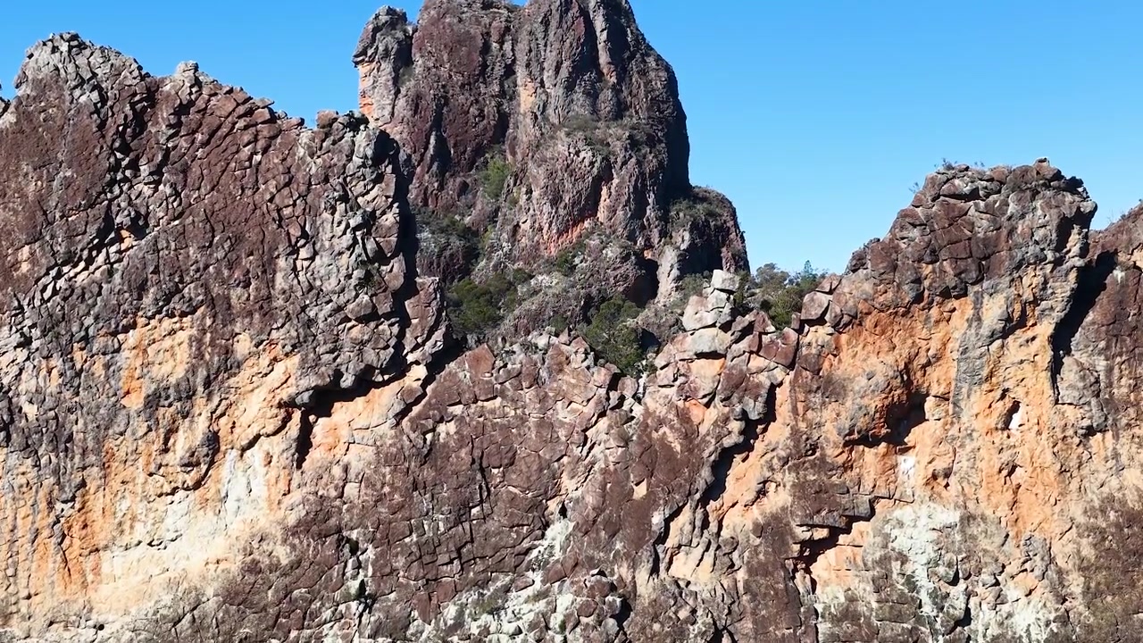 Ampia inquadratura di antiche cime vulcaniche e scogliere sotto un cielo azzurro limpido in Australia