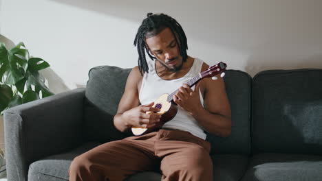 Moderner-Mann-Spielt-Ukulele-In-Nahaufnahme,-Typ-Mit-Dreadlocks-Spielt-Gitarre