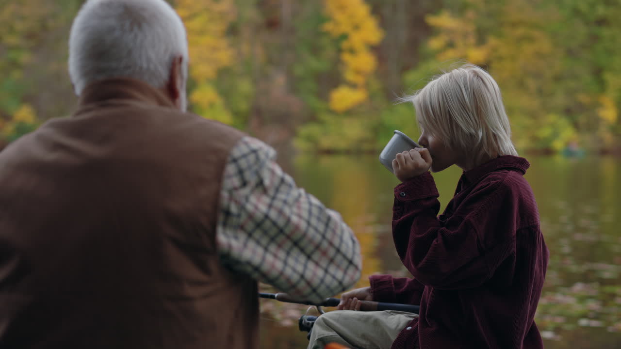 Grandfather and Grandchild Enjoying a Peaceful Boat Ride on an Autumn Lake