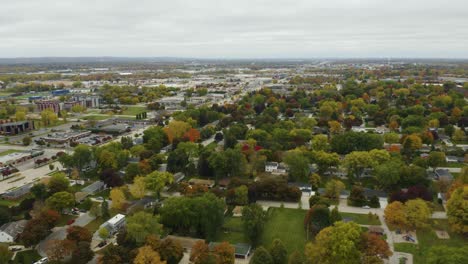 drone flies backwards over suburban homes with fall colors