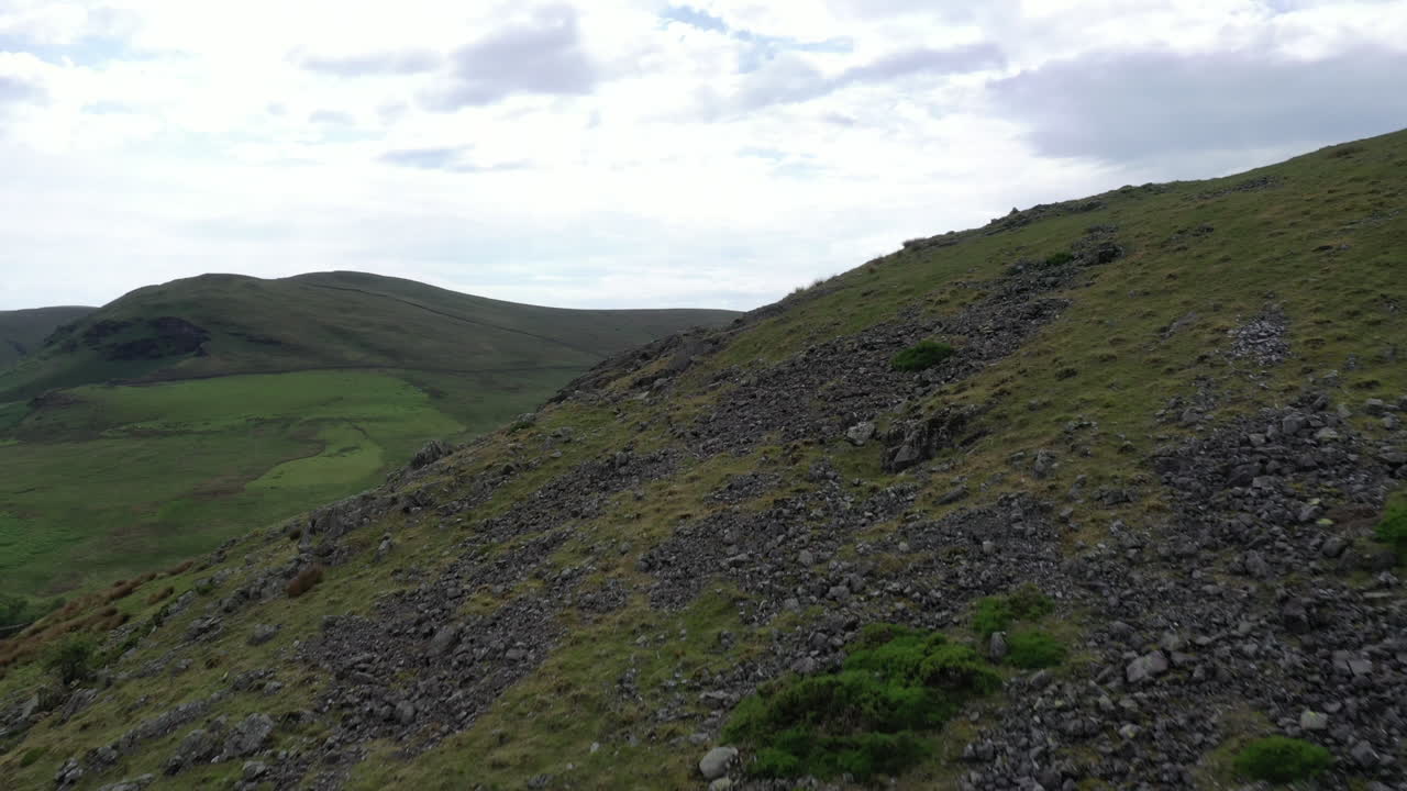 화창한 날 영국 호수 지구에서 뒤의 풍경을 드러내기 위해 언덕 위로 공중 촬영