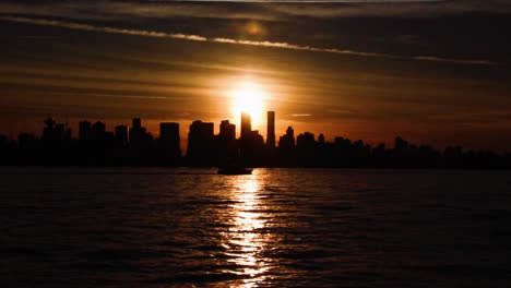 bel tramonto giallo sulle sagome dello skyline di vancouver mentre un piccolo yacht sta navigando nel porto di vancouver