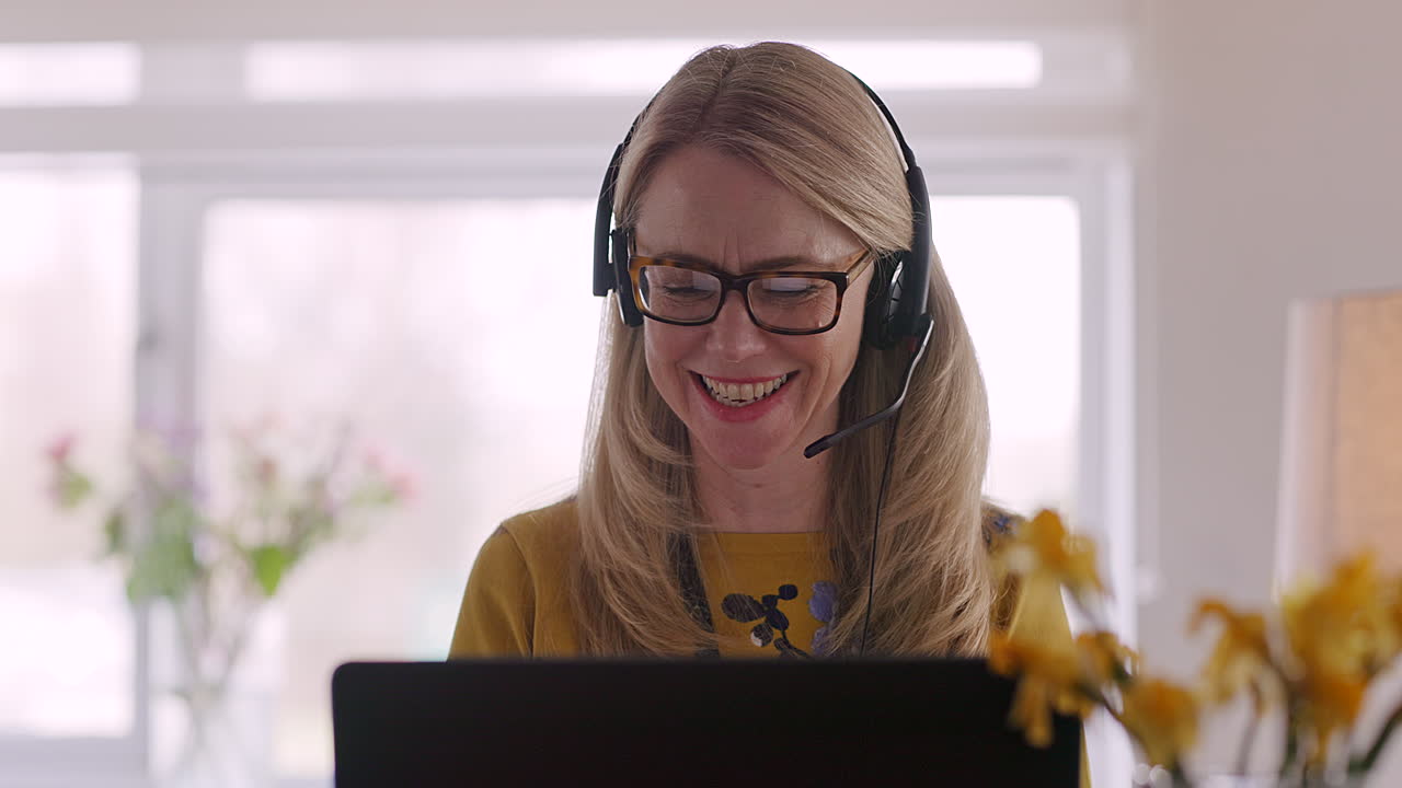 Kvinde med headset arbejder hjemmefra