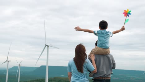 concept of progressive happy family enjoying their time at the wind turbine farm