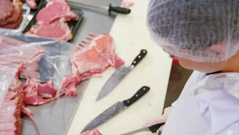 carnicero que corta carne cruda